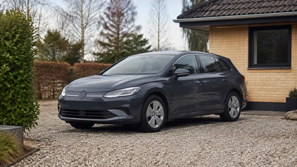 Praktisk elektrisk familiebil på en dansk indkørsel